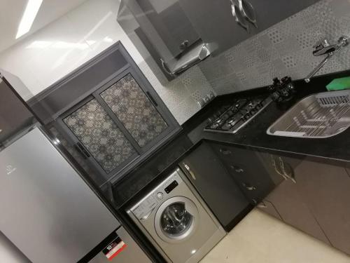 a kitchen with a sink and a washing machine at Adrarhost in Agadir