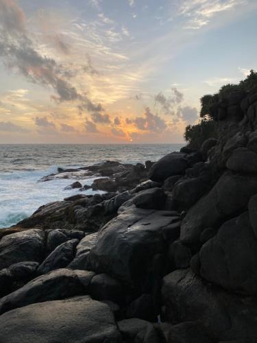 a group of rocks on the shore of the ocean at Una Beach Hotel & OLU Cafe in Unawatuna