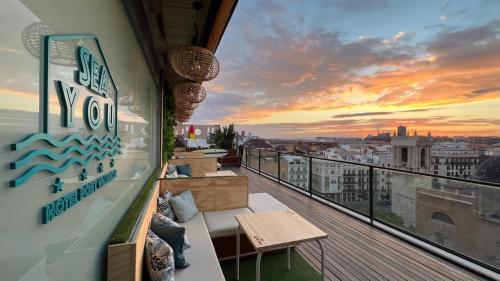 a balcony with a view of the city at sunset at Sea You Hotel Port Valencia in Valencia