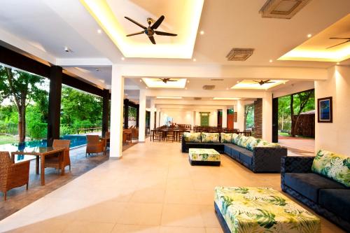 a large living room with couches and a ceiling fan at The Lake Forest Hotel in Anuradhapura