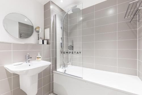 a bathroom with a sink and a tub and a mirror at Modern Private Apartment -Balcony-Tube Station in London