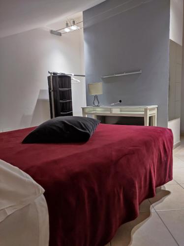 a bedroom with a bed with a red blanket and a desk at La terrazza di Maja in Chieti