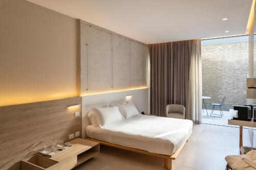 a hotel room with a bed and a desk at Posia Retreat & Spa UNA Esperienze in San Foca