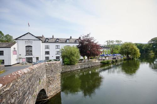 a bridge over a river in front of a building at The Swan Hotel and Spa in Newby Bridge