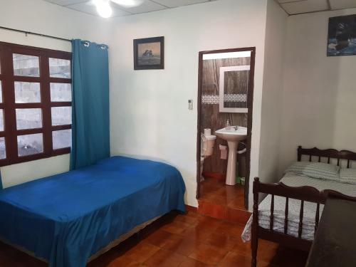 a bedroom with a blue bed and a sink at Rancho villas de alicia in La Paz