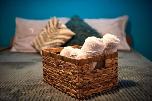 a basket with towels sitting on a bed at Apartman Azra in Kikinda