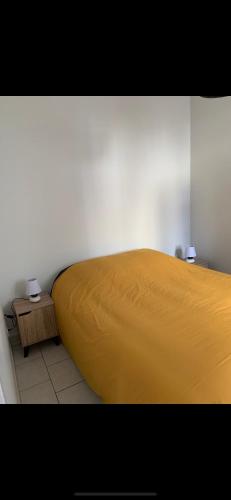 - une chambre avec un lit jaune et une table dans l'établissement Appartement Vals-les-Bains, à Vals-les-Bains