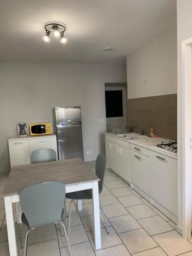 a kitchen with a table and chairs and a kitchen with a refrigerator at Appartement Vals-les-Bains in Vals-les-Bains