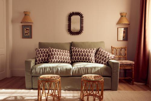 a living room with a green couch and two stools at Cristine Bedfor Mahon in Mahón
