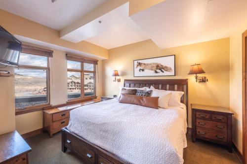 a bedroom with a large bed and two windows at Ski In Ski Out Corner Unit Direct Views Slopes Gondola Conde Nast and Forbes Winner in Park City