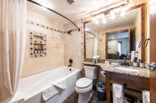 a bathroom with a tub and a toilet and a sink at Ski In Ski Out Corner Unit Direct Views Slopes Gondola Conde Nast and Forbes Winner in Park City