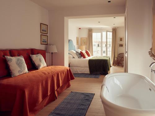 a living room with a couch and a bed and a mirror at Cristine Bedfor Mahon in Mahón
