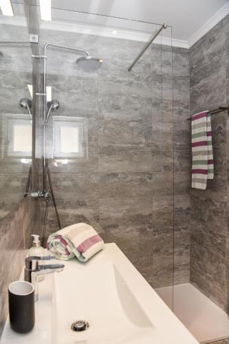 a bathroom with a sink and a shower at Alma do Mar in Baleal