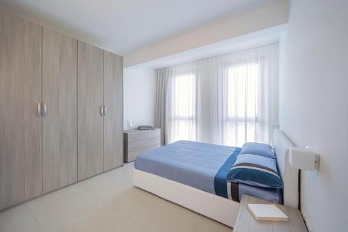 グロッタンマーレにあるDimora Di Mareのベッドルーム(青いベッド1台、木製キャビネット付)