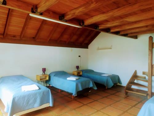 two beds in a room with wooden ceilings at Tanino Guest House in Mendoza