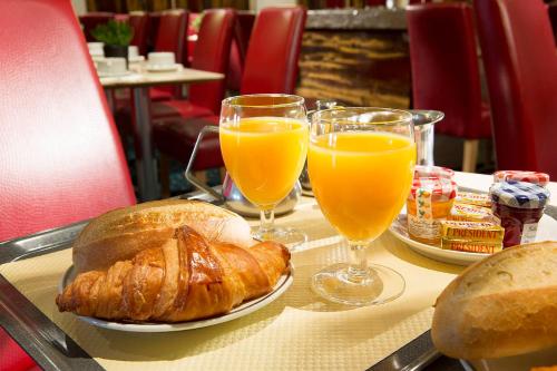 a table with bread and two glasses of orange juice at HOTEL DU PRINTEMPS in Paris