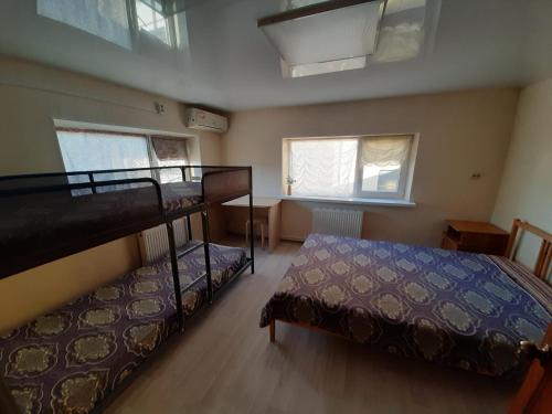 プリモルスコ・アフタルスクにあるAhtarskij Dvorikのベッドルーム1室(二段ベッド2組、窓2つ付)が備わります。