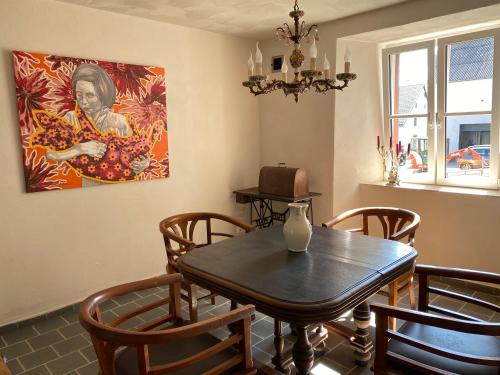 una sala da pranzo con tavolo, sedie e un dipinto di House Kellisch 1822 a Steffeln