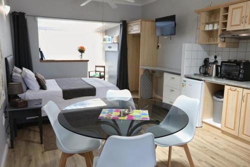 a bedroom with a bed and a table and chairs at Caesar's Self-catering Open Plan Suite in Somerset West