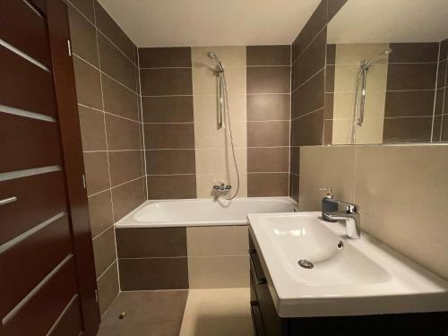 a bathroom with a sink and a shower and a tub at Apartmány Diamant in Bratislava