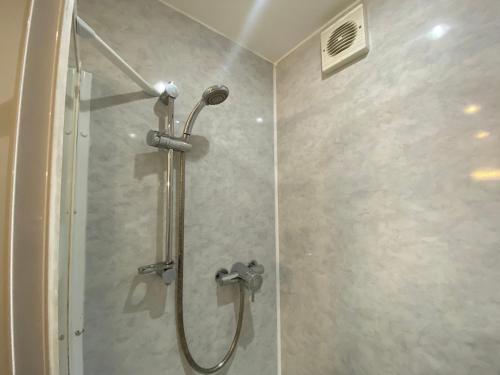 a shower stall with a glass shower door at Park View House Hotel in Edinburgh