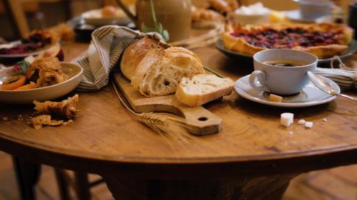 a table with a plate of bread and a cup of coffee at Hotellerie de l'Abbaye du Désert in Bellegarde