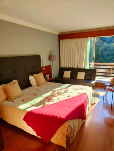 a bedroom with a large bed and a large window at São Cristóvão Nature Country Hotel in Venda Nova