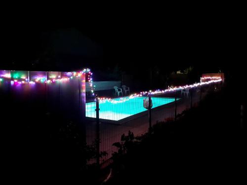 - une piscine éclairée par des lumières de Noël la nuit dans l'établissement Mobilhome & Piscine - Sud-Alpilles - Oliveraie bio, à Entressen