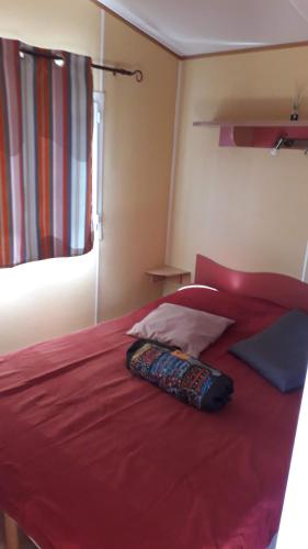 - une chambre avec un lit rouge et une couverture rouge dans l'établissement Mobilhome & Piscine - Sud-Alpilles - Oliveraie bio, à Entressen