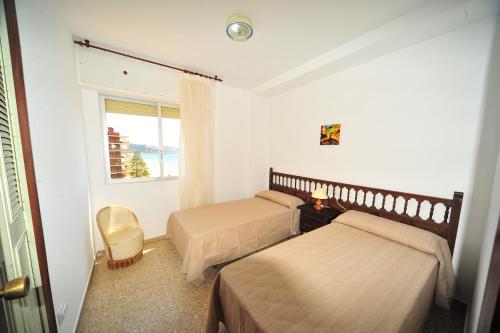 a hotel room with two beds and a window at Coimbra vista mar Orangecosta in Benicàssim