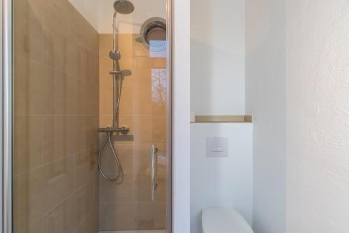 uma casa de banho com um chuveiro e uma porta de vidro em SUITE & APART em Berlim