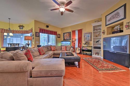 a living room with a couch and a flat screen tv at Elegant Valrico Home about 15 Mi to Downtown Tampa! in Valrico