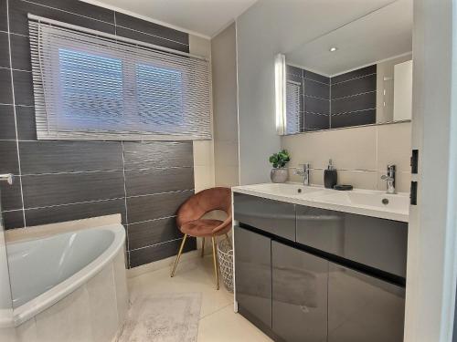 a bathroom with a tub and a sink and a bath tub at Chalet ( Paris , Disneyland ) in Gretz-Armainvilliers