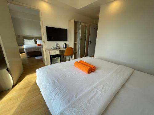 a bedroom with a bed with an orange towel on it at iCom Marina Sea View in Maafushi