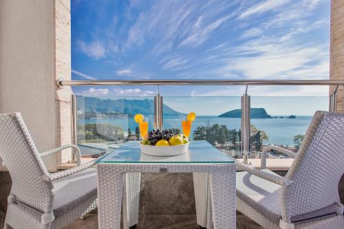 a table with a bowl of fruit on a balcony at Hotel Bracera in Budva