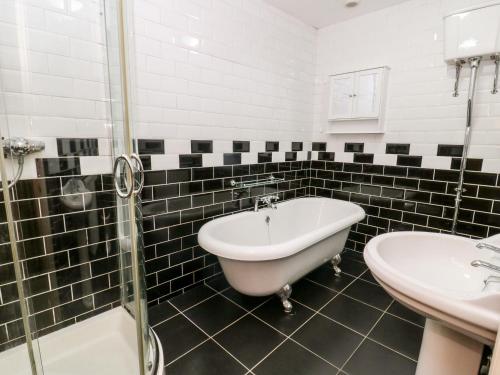 a bathroom with a tub and a sink and a bath tub at Blacksmiths Retreat, 50 Holgate Road in York