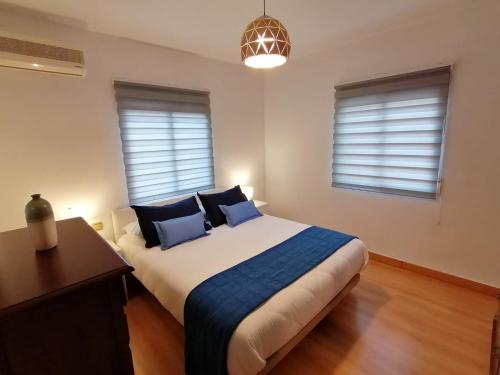 a bedroom with a large bed with blue pillows at Spacious Apartment in Armilla