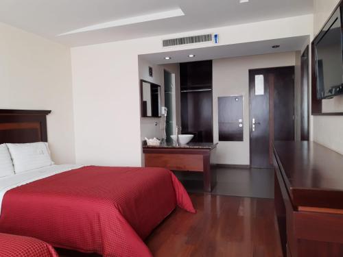 a bedroom with a red bed and a bathroom at HOTEL MADEIRA in Mexico City