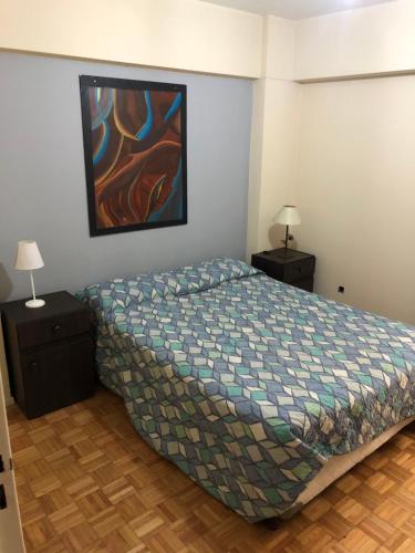 um quarto com uma cama e duas mesas de cabeceira com candeeiros em Departamento Av. Colon (Ubicacion 9.8 puntos) em Mendoza