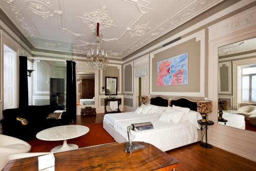a bedroom with a white bed and a living room at Palacete Chafariz Del Rei - by Unlock Hotels in Lisbon