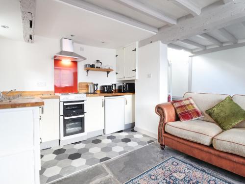 a living room with a couch and a kitchen at 1 Hendom in Corwen