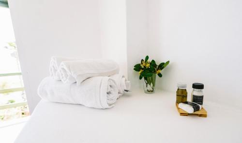 a white room with towels and a vase of flowers at Posada Paradiso in José Ignacio