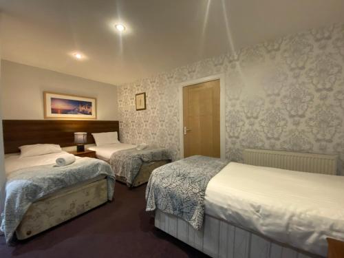 two beds in a hotel room with two beds at Park View House in Edinburgh