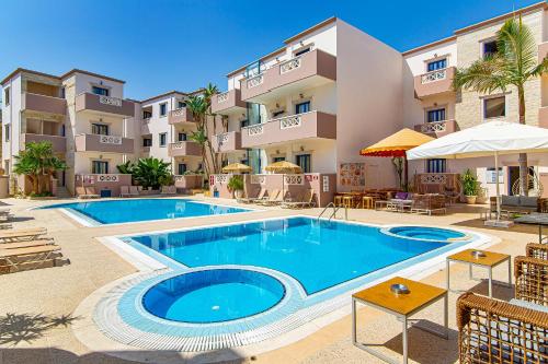 a swimming pool in front of a building at Ilios Malia Hotel Resort in Malia