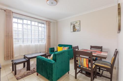 ein Wohnzimmer mit einem grünen Sofa und einem Tisch in der Unterkunft Fully furnished 1-bedroom Apartment in Eldoret in Eldoret