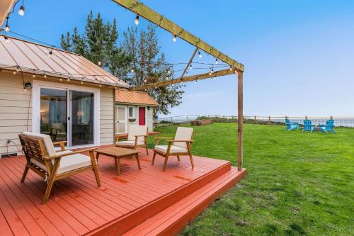 a deck with chairs and a table and chairs at @ Marbella Lane – Wave House, Your Oceanfront Retreat! in Oak Harbor