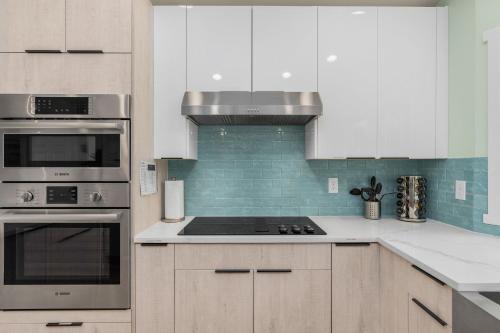 a kitchen with white cabinets and a stove top oven at @ Marbella Lane – Wave House, Your Oceanfront Retreat! in Oak Harbor
