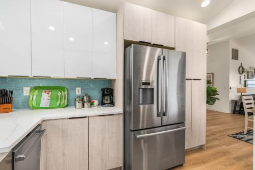 a kitchen with white cabinets and a stainless steel refrigerator at @ Marbella Lane – Wave House, Your Oceanfront Retreat! in Oak Harbor