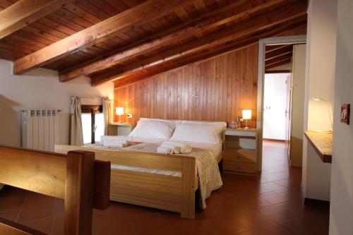 a bedroom with a large bed with a wooden wall at Ca' Marietta al Centro Storico in Borno