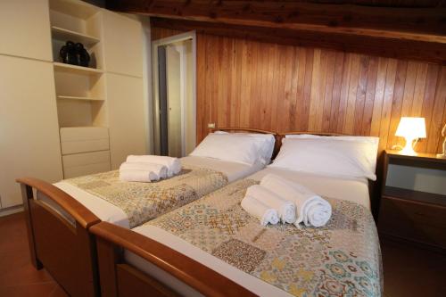 two beds in a bedroom with towels on them at Ca' Marietta al Centro Storico in Borno